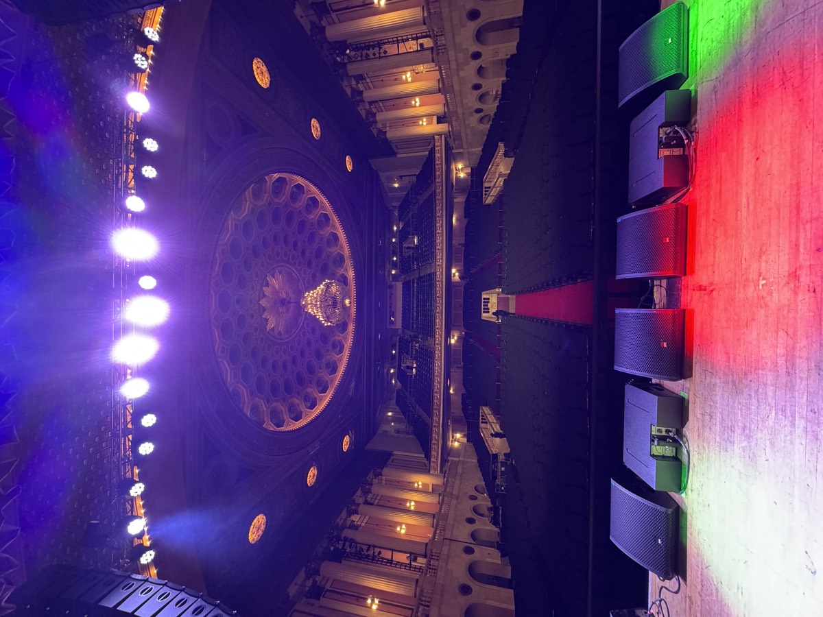 Flown line array and stage monitors set on a historic theater stage